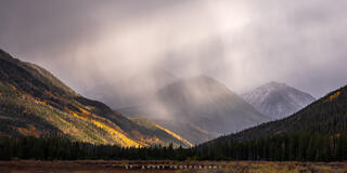 Light shafts piercing through the clouds above Christmas meadows in the mountains of Utah