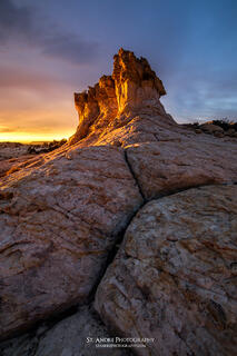 A rock looks like a lions nose while a dramatic sunrise unfolds above the structure near esacalante in southern Utah