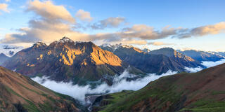 The university range mountains with clouds at their base and dramatic light hitting the peaks. 