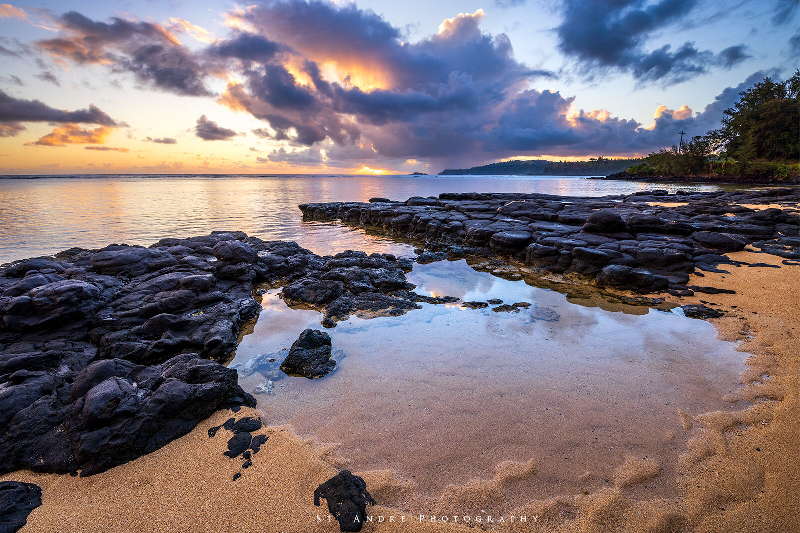A tidal pool on the island of Hawaii at sunrise with the clouds reflecting in the still tidal pool waters. There were a few little...
