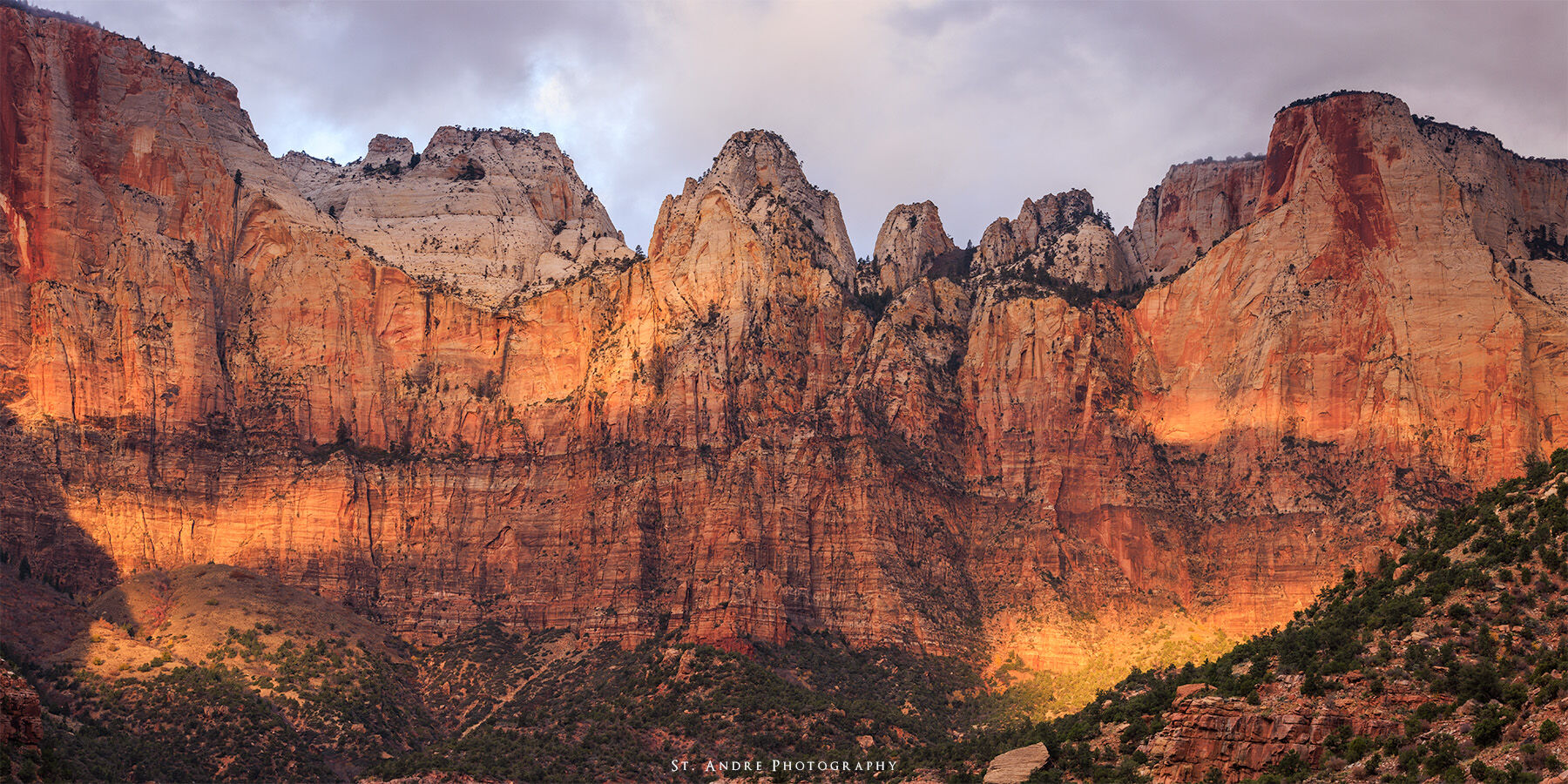 The Towers of the Virgin in Zion National Park with dappled light across the cliff faces. 