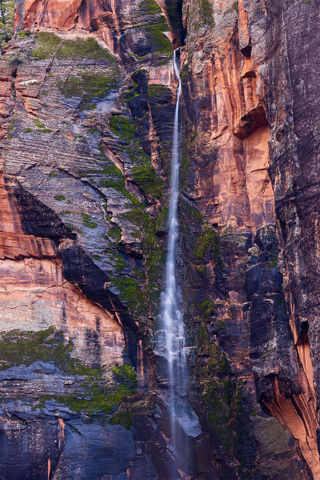 A wispy waterfall cascades out of Hidden Canyon next to the great white throne