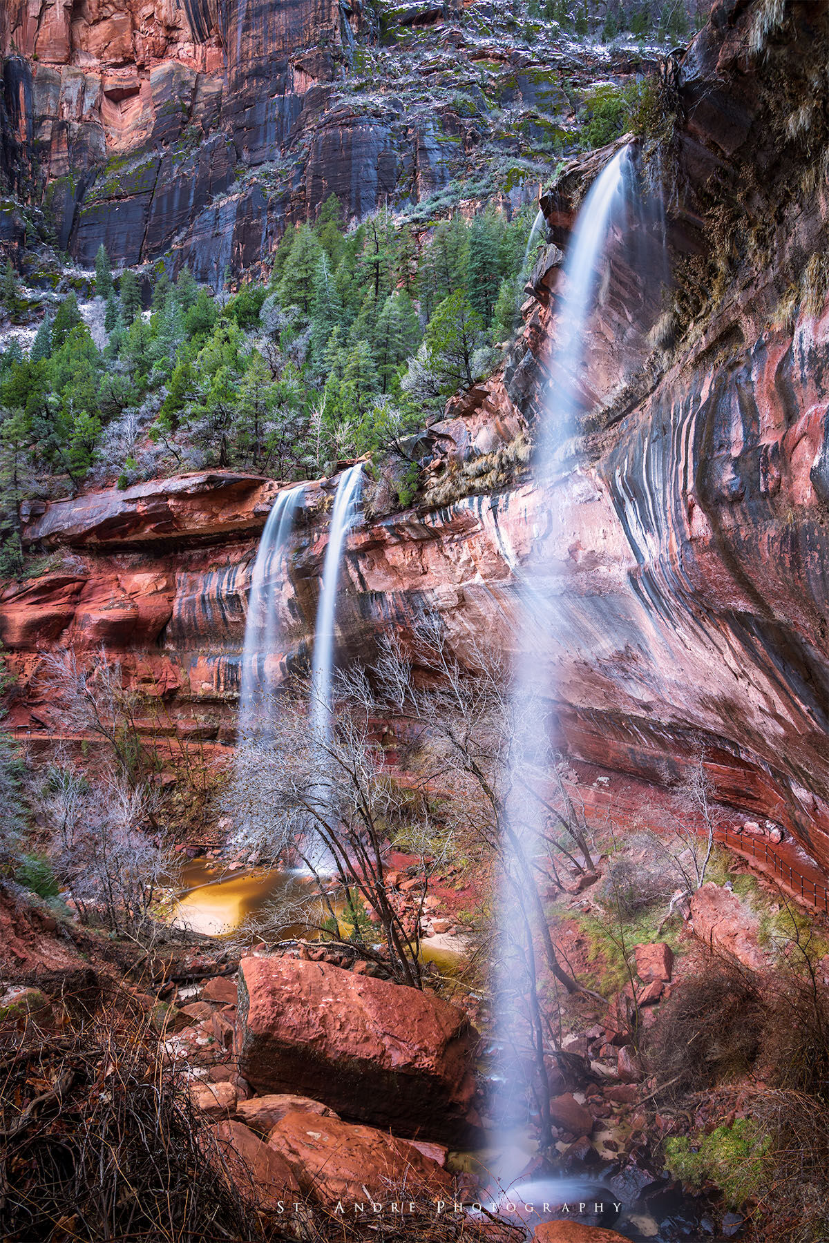 A tripple waterfall cascades off of a cliff at Zion National Park