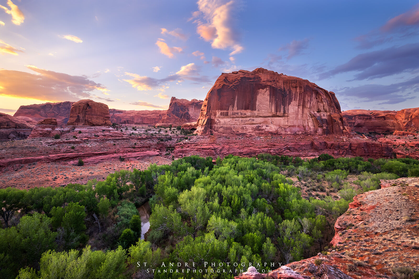 An image of the Escalante canyon with cottonwoods trees large rock structures and a beautiful sunset. 