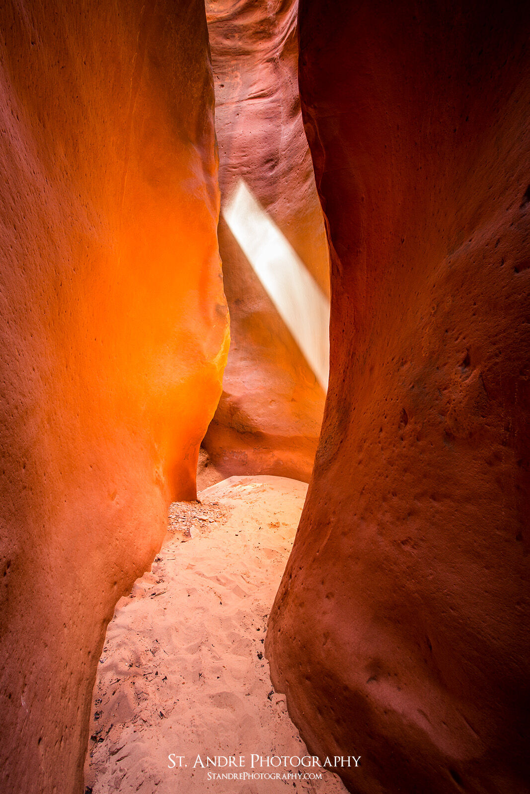 A crimson orange slot canyon with a light beam located in southern Utah