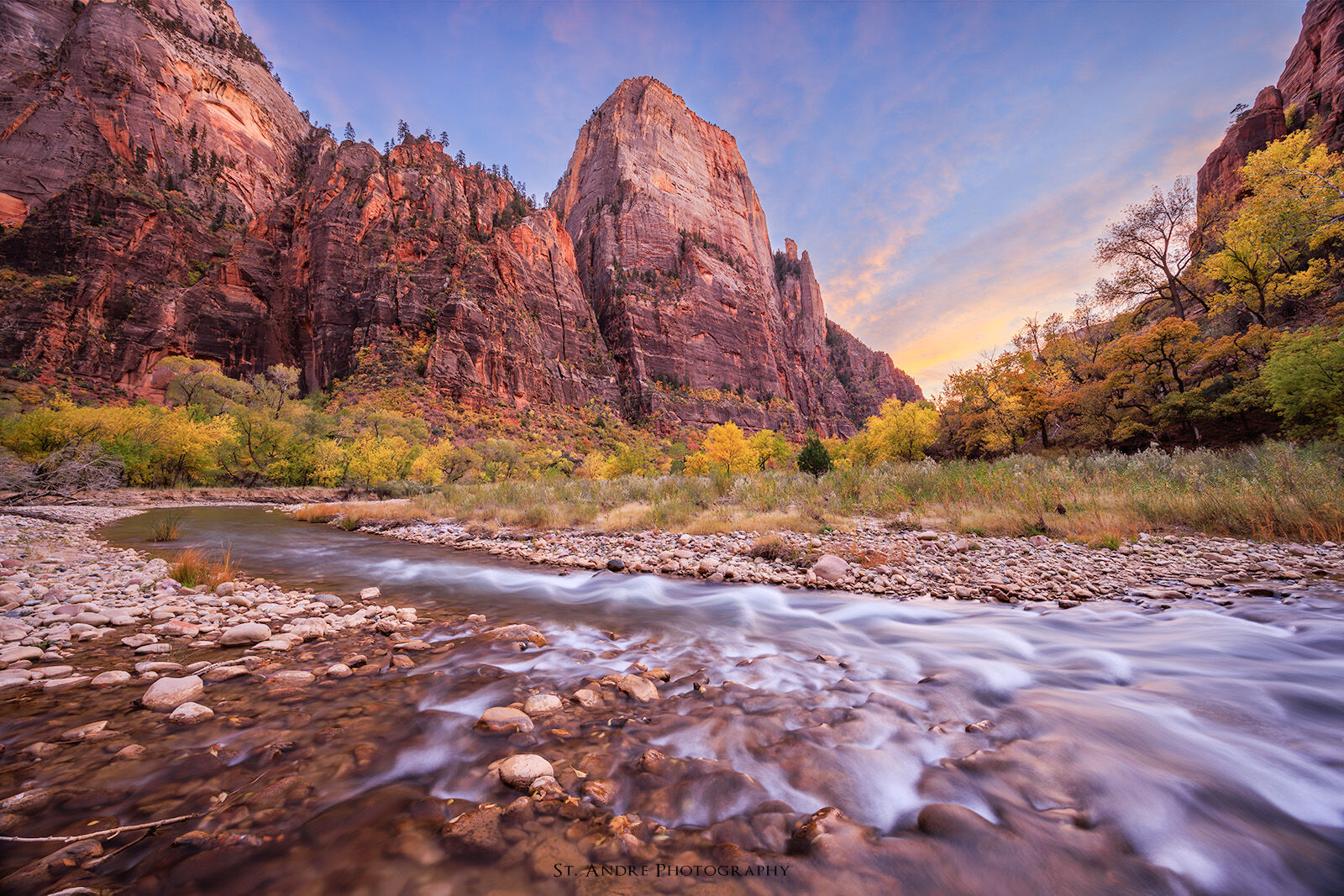The Great White Throne in Zion National Park with fall colors and the virgin river flowing through the seen. 