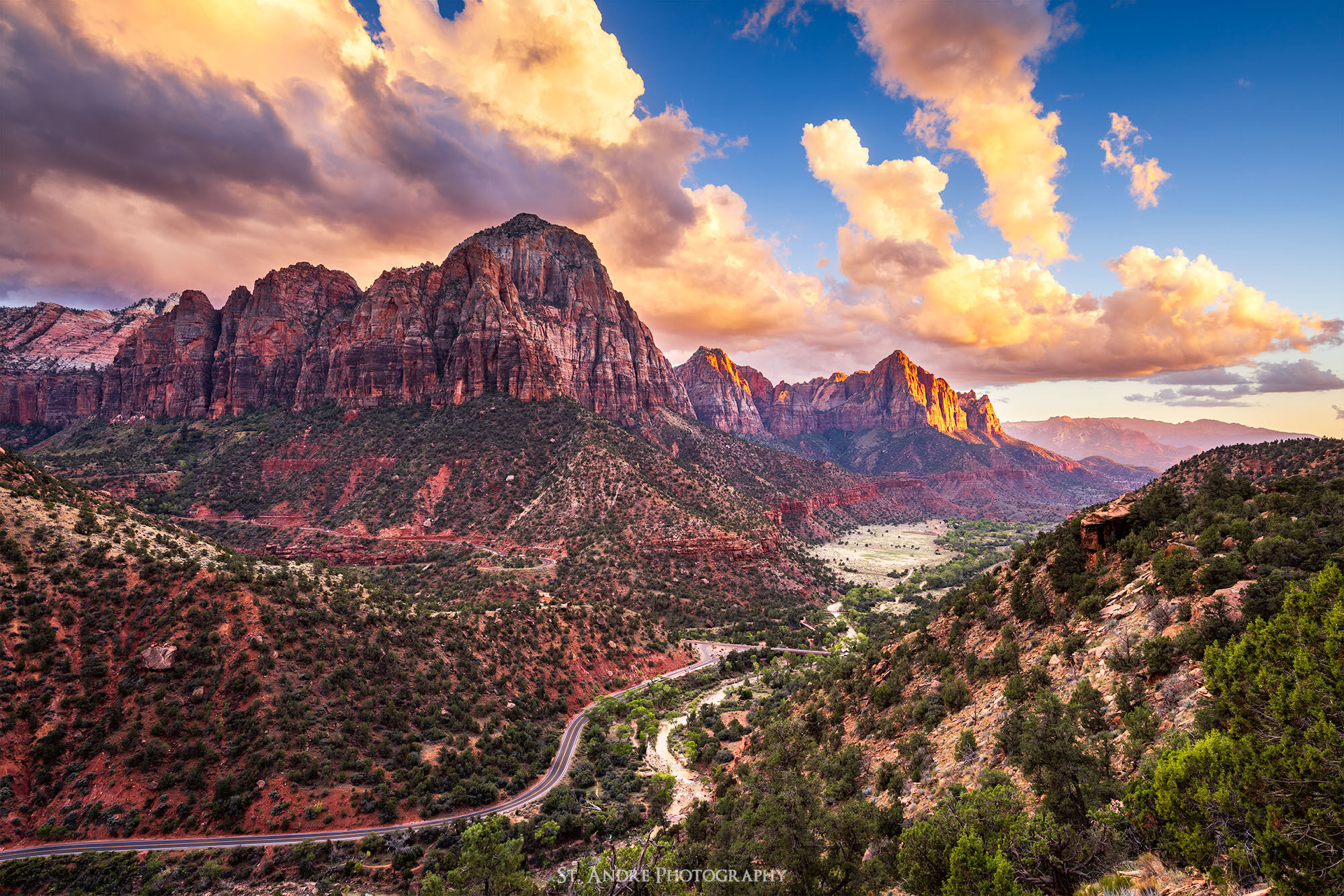 Bridge mountain and the Watchman mountain are lit up at sunset in Zion National Park. The river and road lead the viewer through the scene. 
