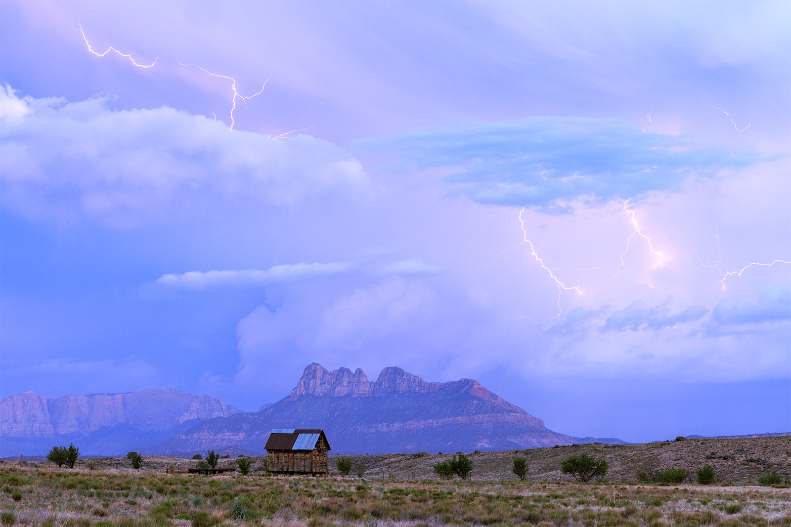 Smithsonian Thunder Lightning over Smithsonian butte with a small barn in the foreground.