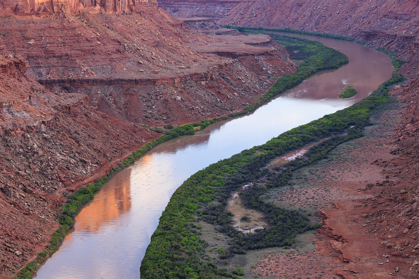 The River Bend (Green River) A long curving turn of the Green River as it cuts its way through the red rock desert. A glowing cliff wall is reflected in the water.