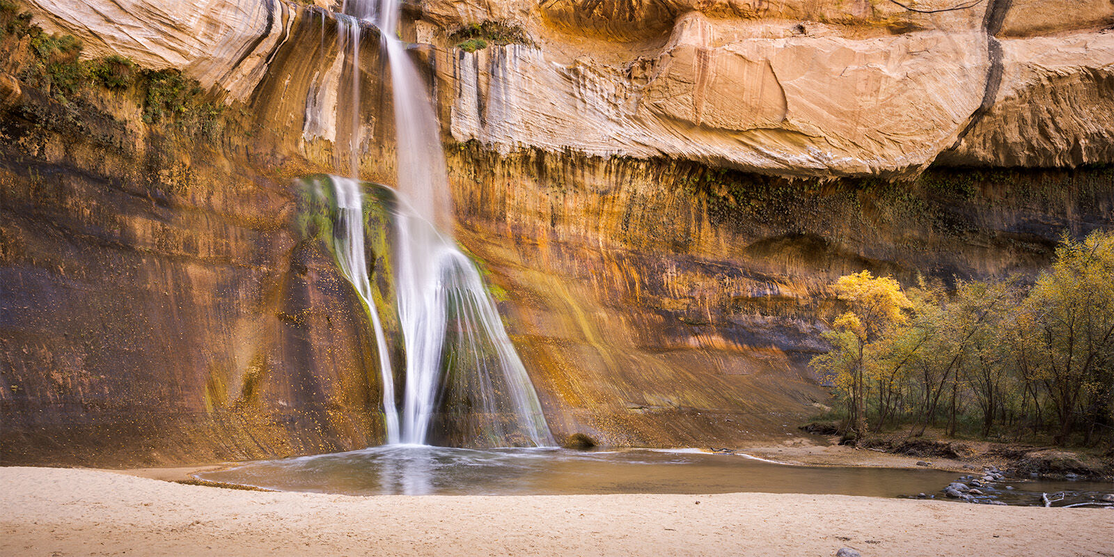 A panoramic image of Calf Creek Falls with a dollop of fall colors.